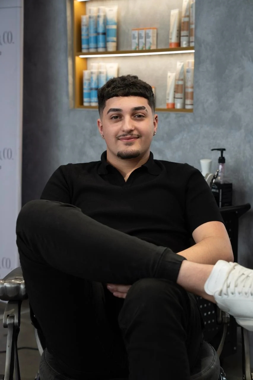 John Doe, Senior Barber, expertly trimming a client's beard
