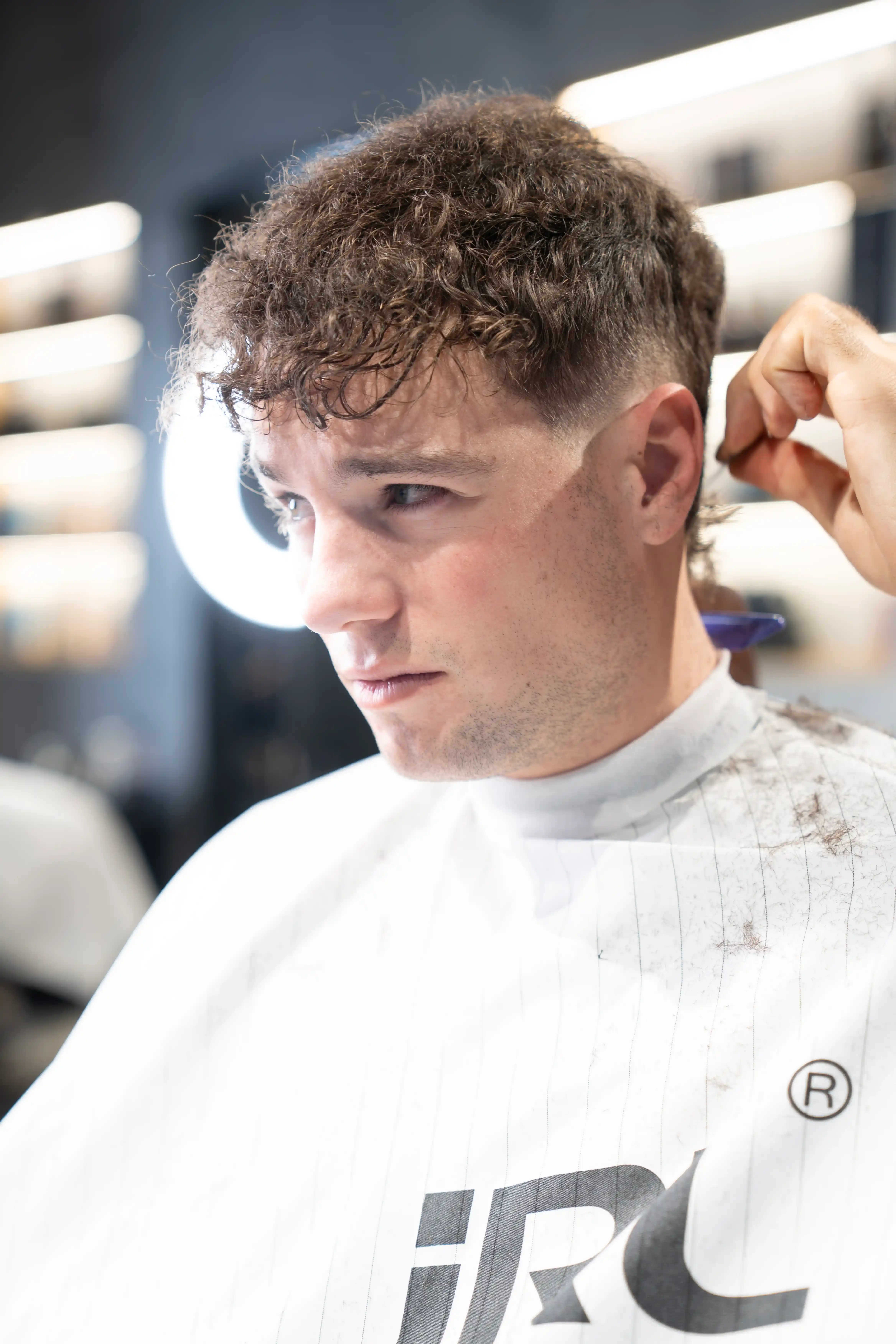 Professional barber Alessandro Romano performing a classic haircut